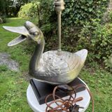 Old vintage lamp representing a duck in silver metal with wooden base