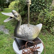 Old vintage lamp representing a duck in silver metal with wooden base
