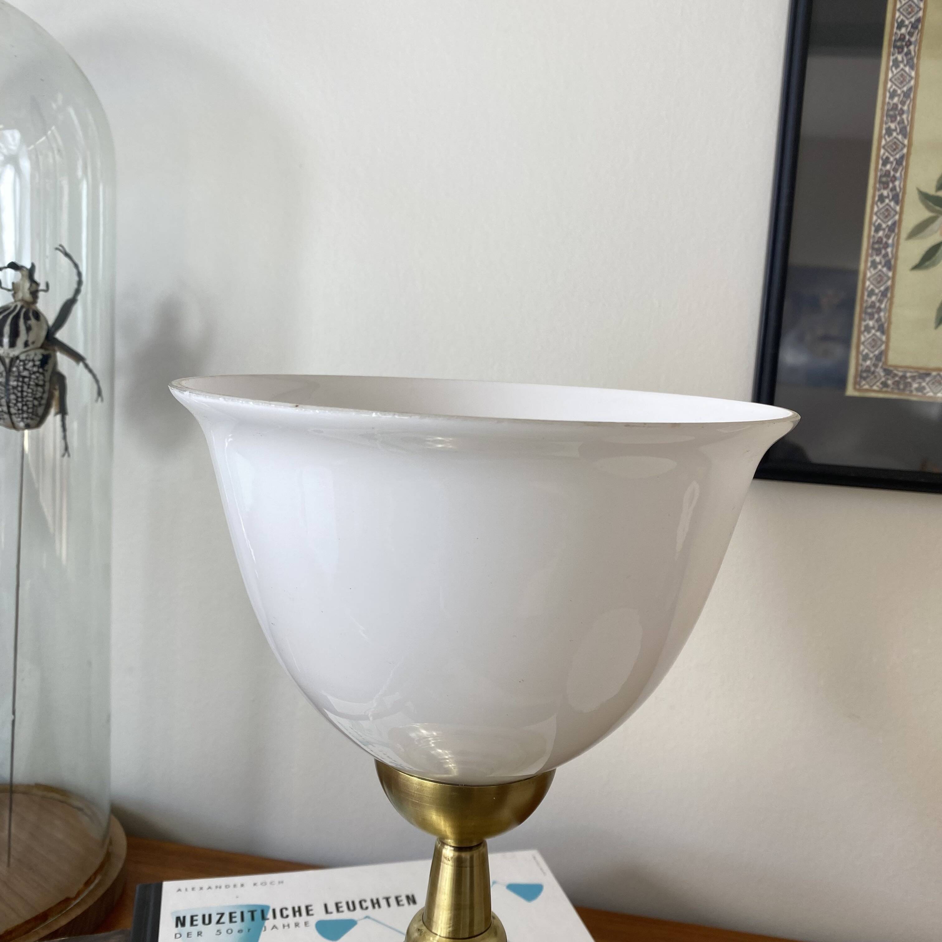 Antique white opaline glass globe table lamp with a brass base.