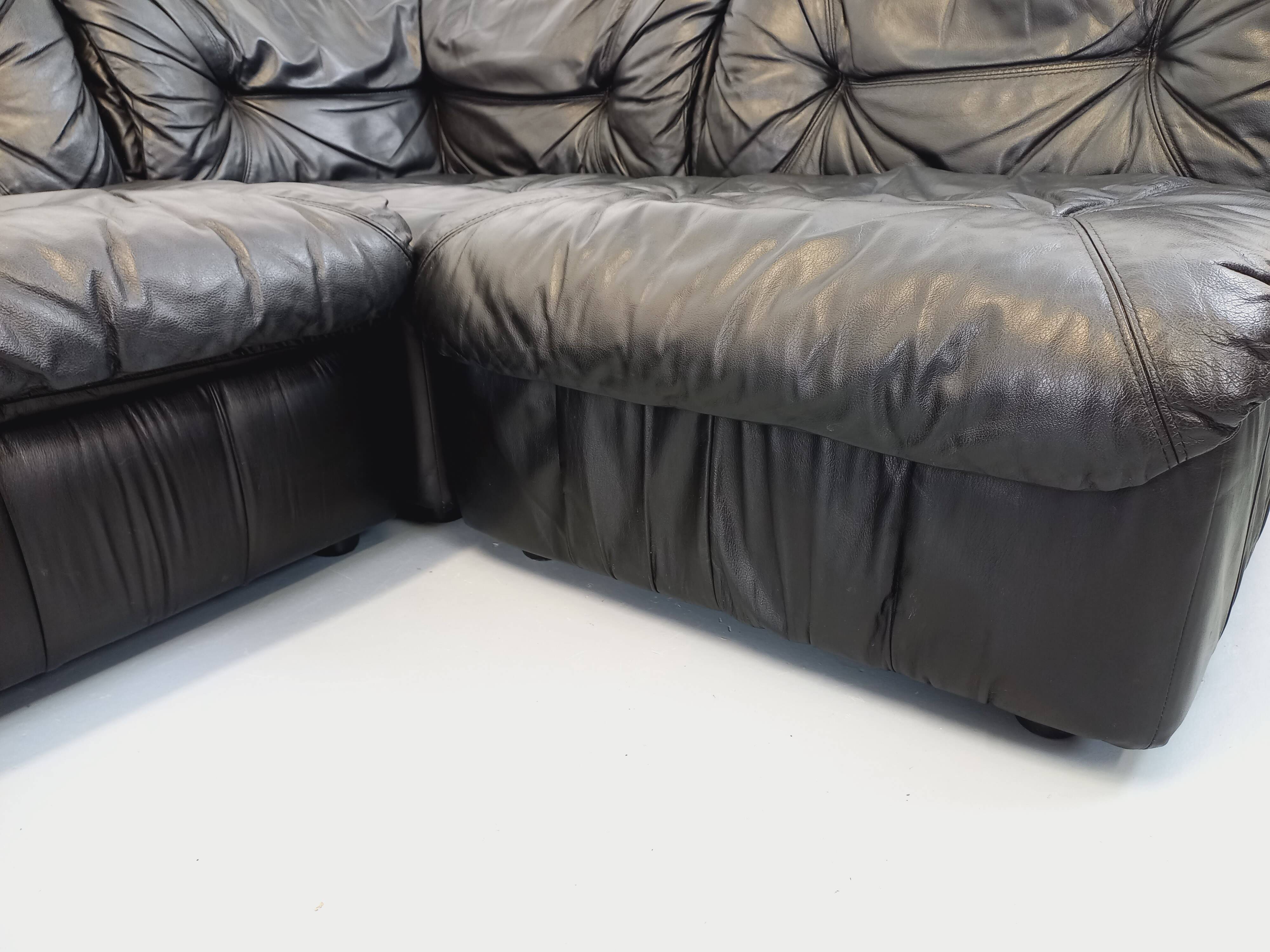 Vintage corner sofa composed of 3 modules in black leather with integrated bed.