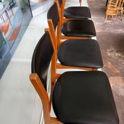 4 Scandinavian chairs in teak and black faux leather.