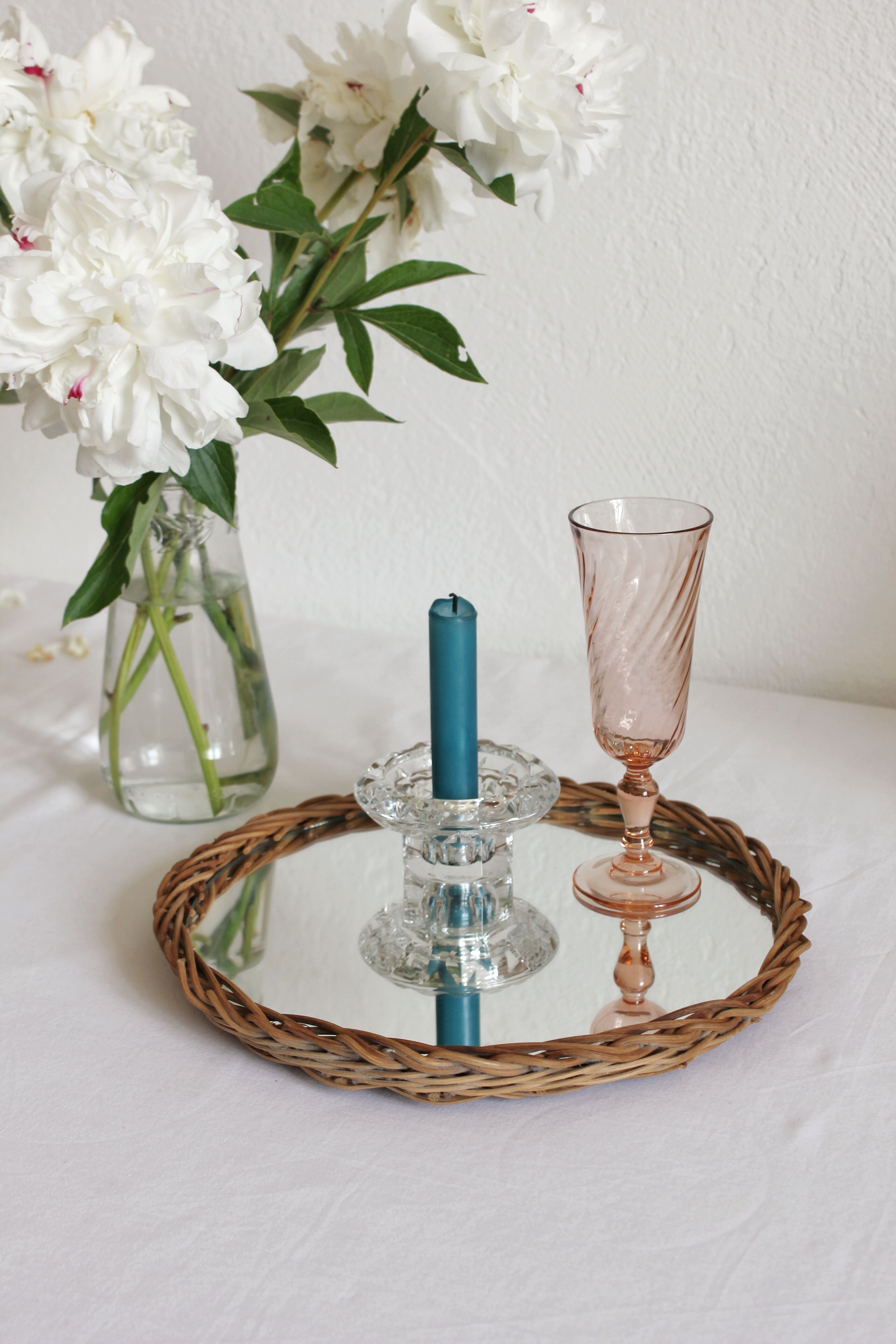Decorative mirrored tray surrounded by vintage rattan/wicker
