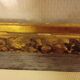 Antique gilded frame with stone lion head ornament on plexiglass