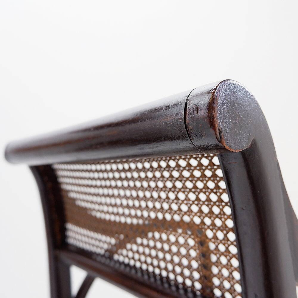Mid-century curved wooden chairs with cane seats and backs.