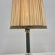 Brass table lamp with green patina and empire-style fabric shade.