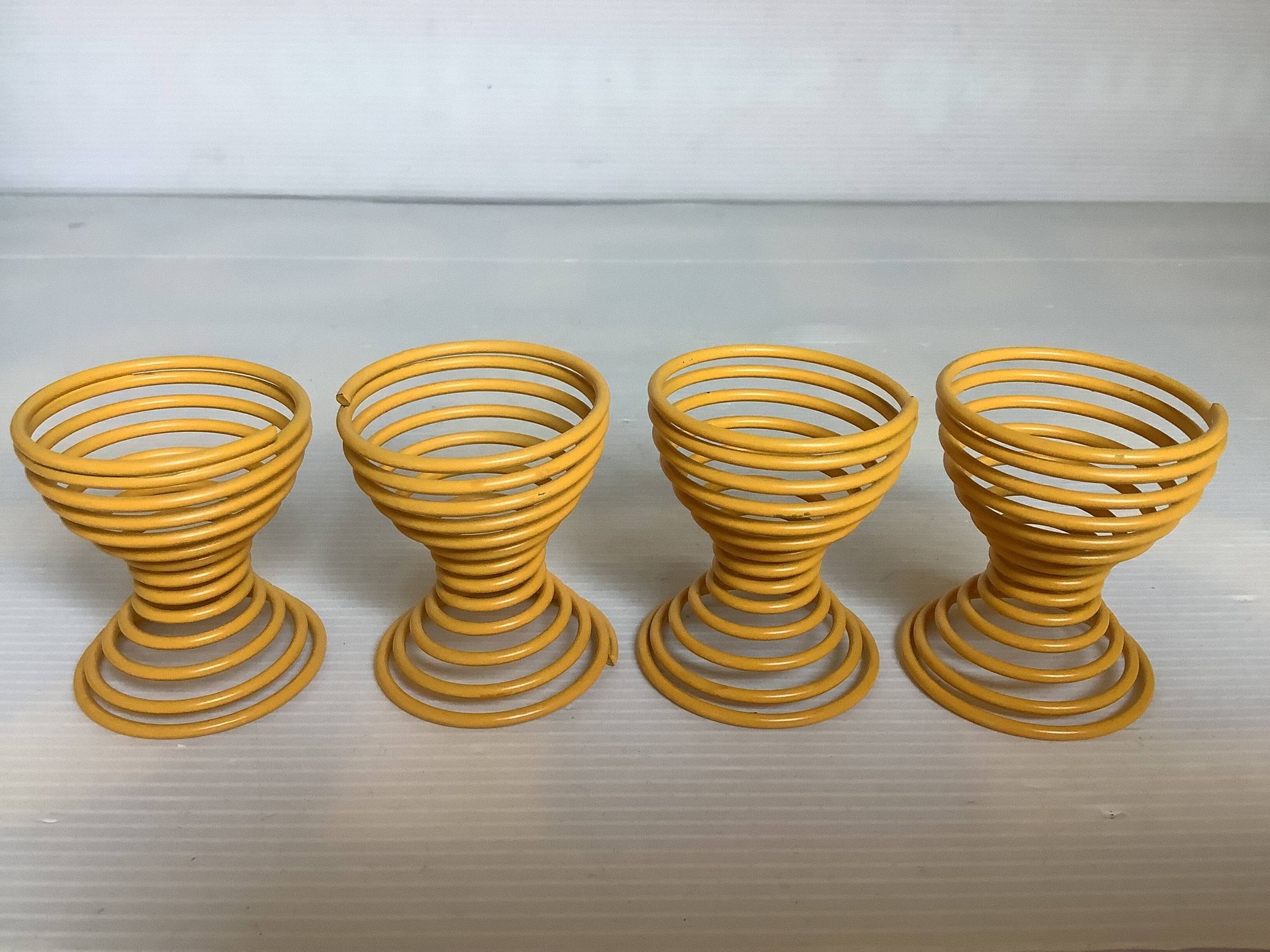 Four yellow spiral spring egg cups