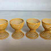 Four yellow spiral spring egg cups