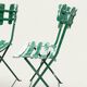 Pair of original patinated folding Parisian bistro chairs.