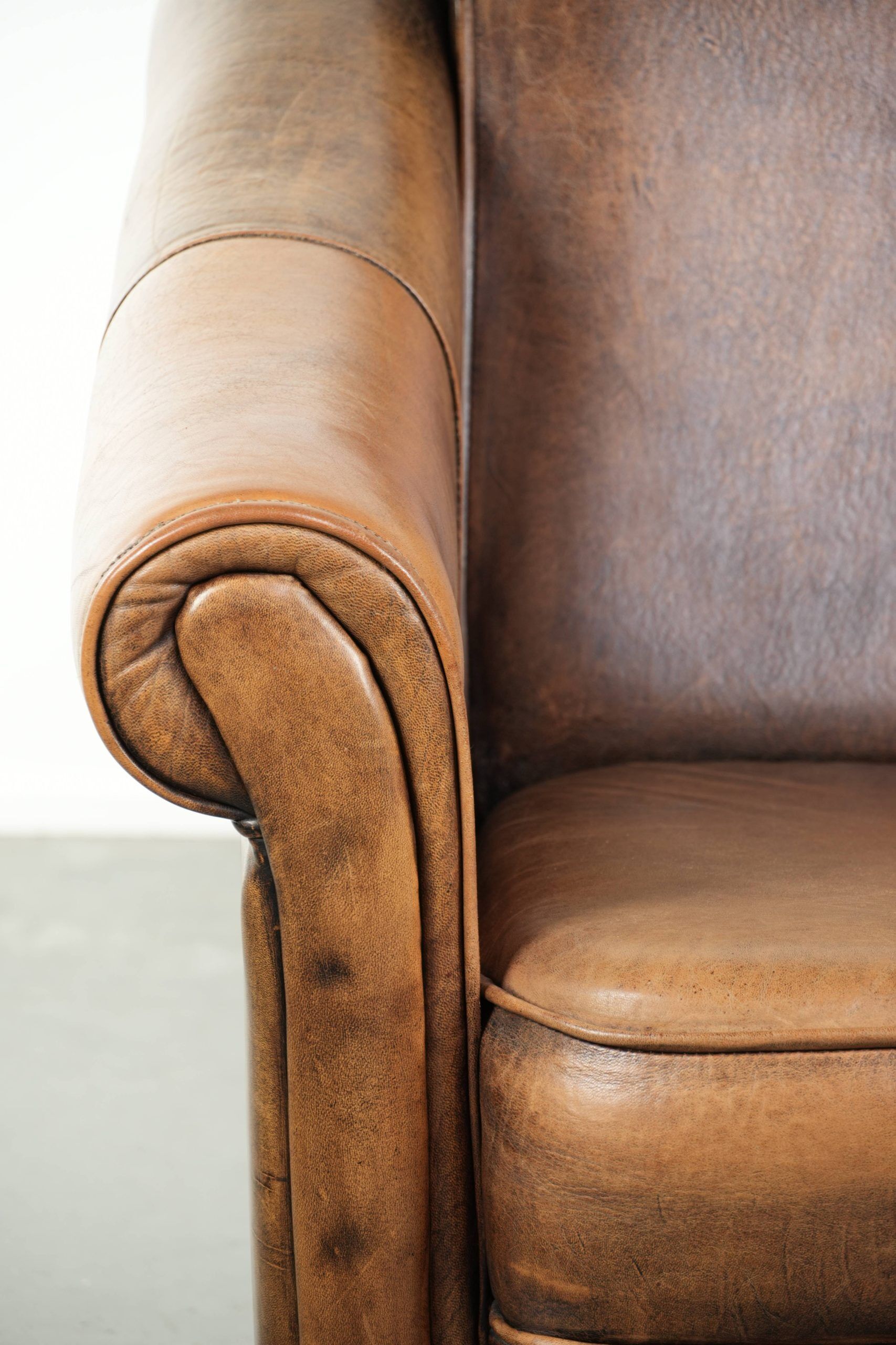 Fauteuil en peau de mouton magnifiquement conçu et confortable, avec un look intemporel et une finition de passepoil assortie.