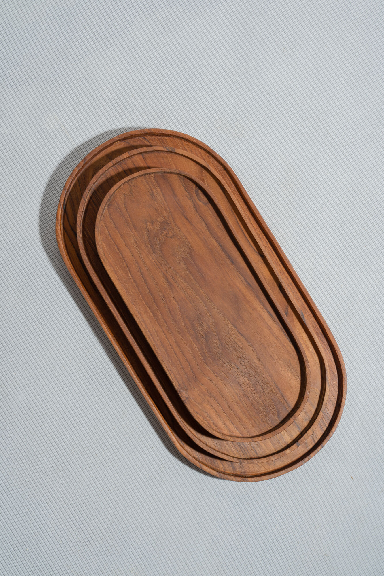 Trio of oval teak trays or cups