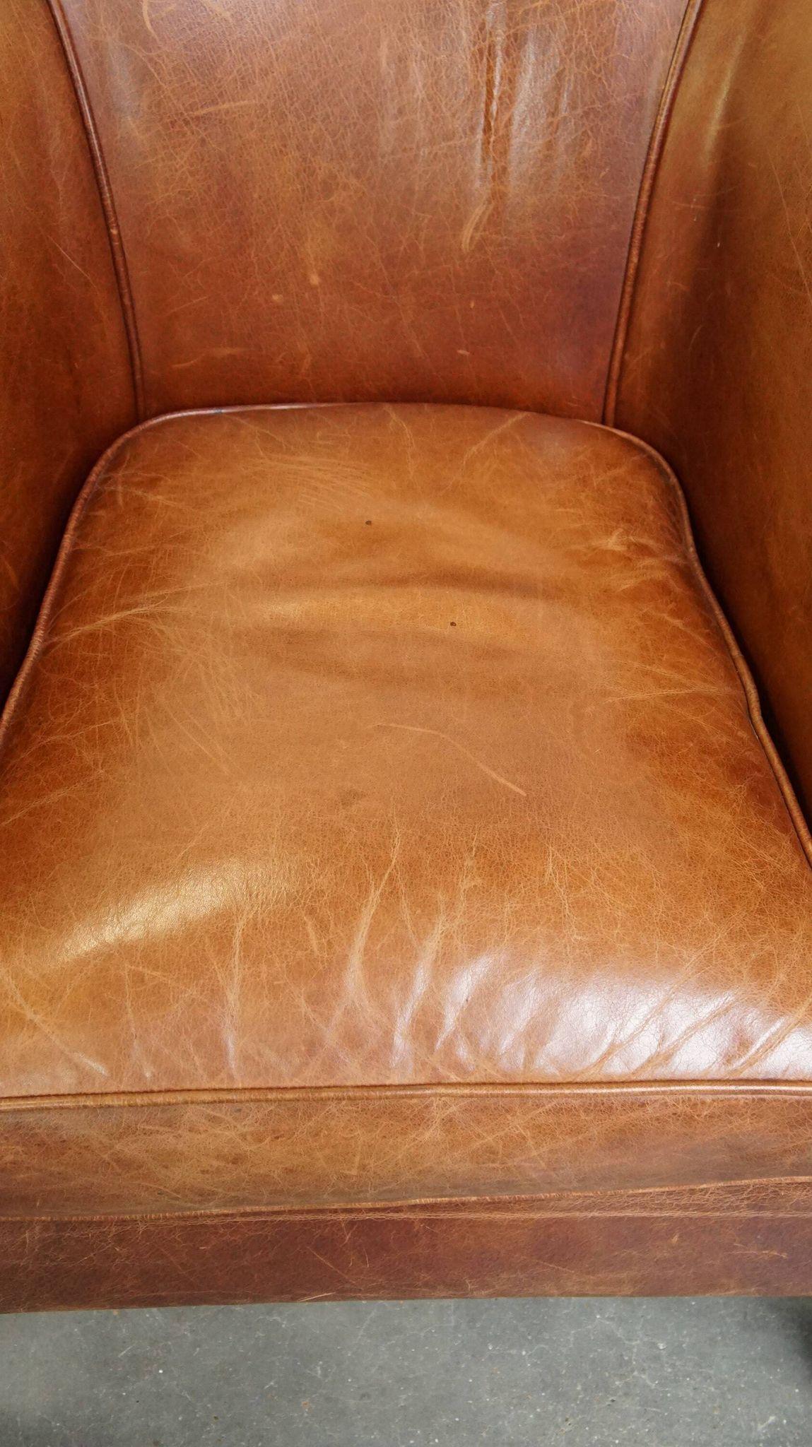 Very comfortable, elegant leather club armchair with a removable seat cushion and timeless design