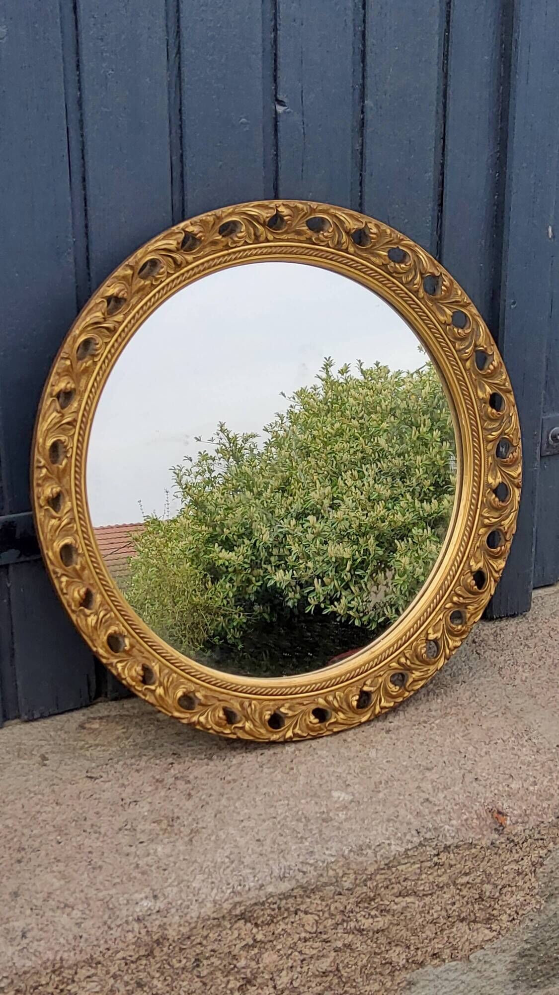 Round neoclassical style mirror in wood and gilded stucco from the 1950s