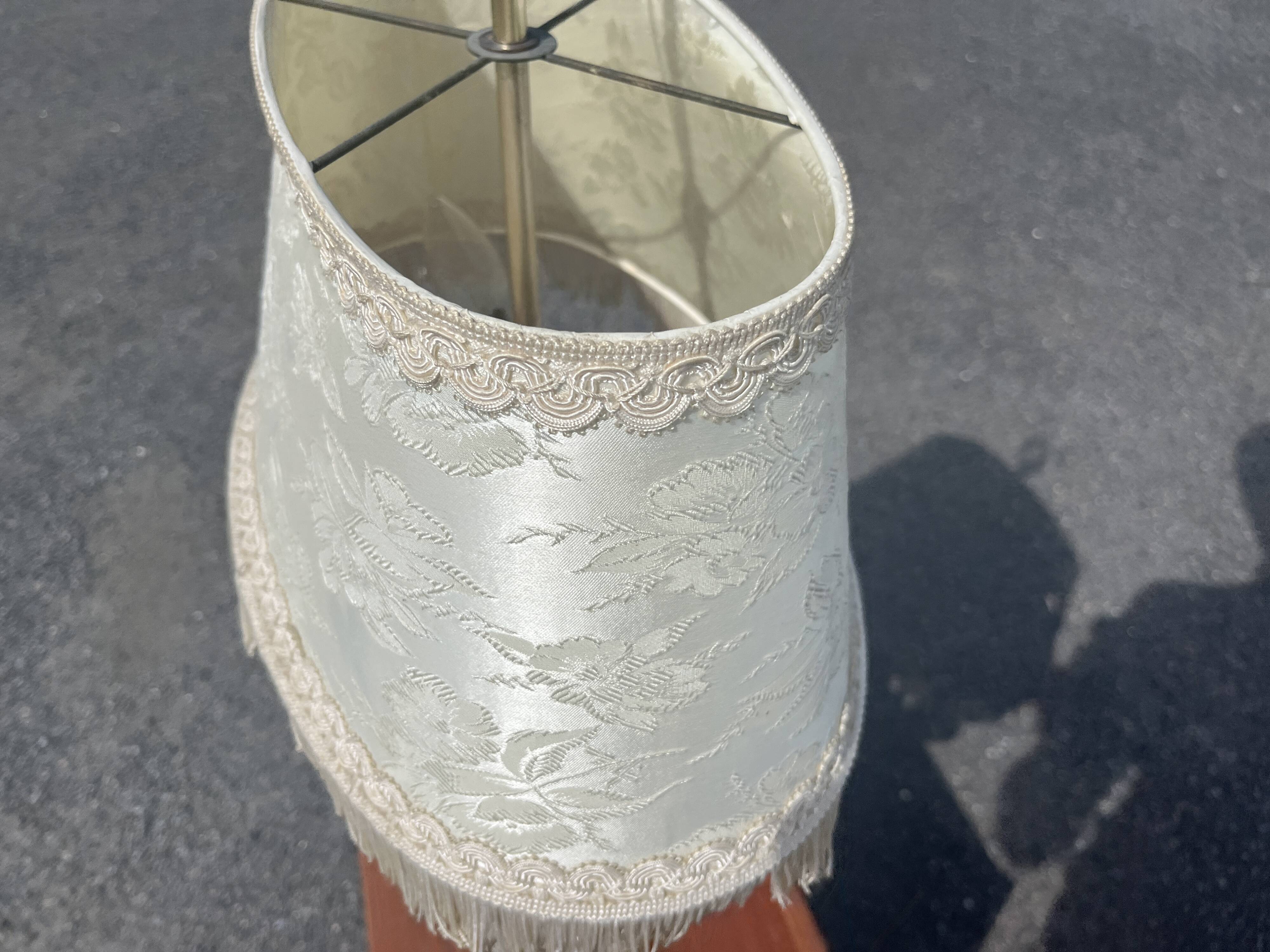 Two-armed hot water bottle lamp in silver metal with fringed fabric shade