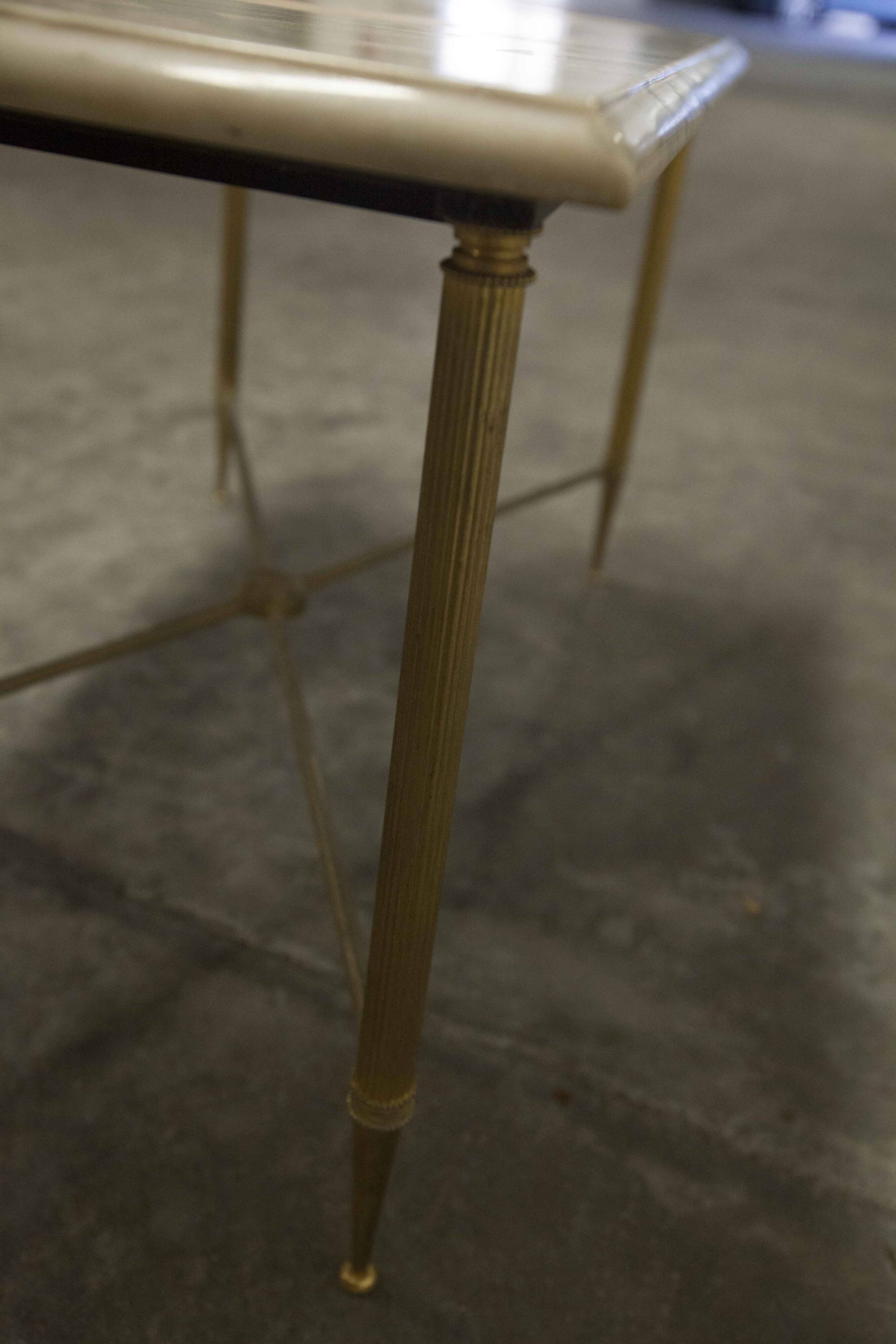 Marble coffee table with brass legs, height 46 cm.