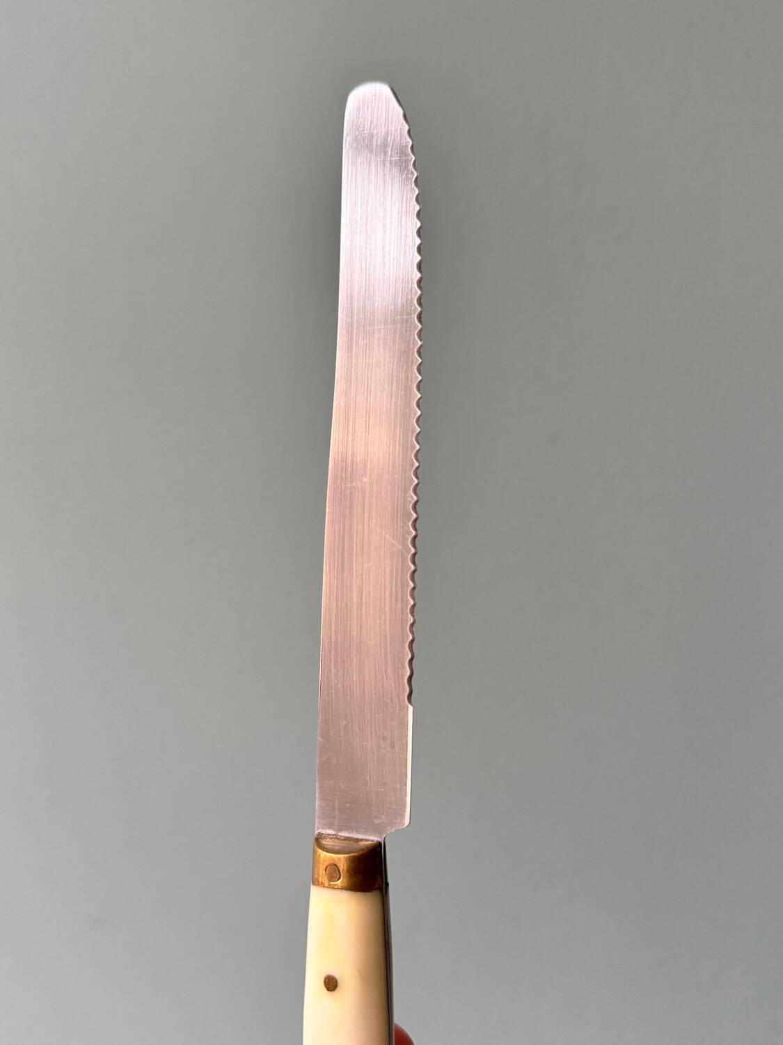 Series of 11 vintage serrated table knives