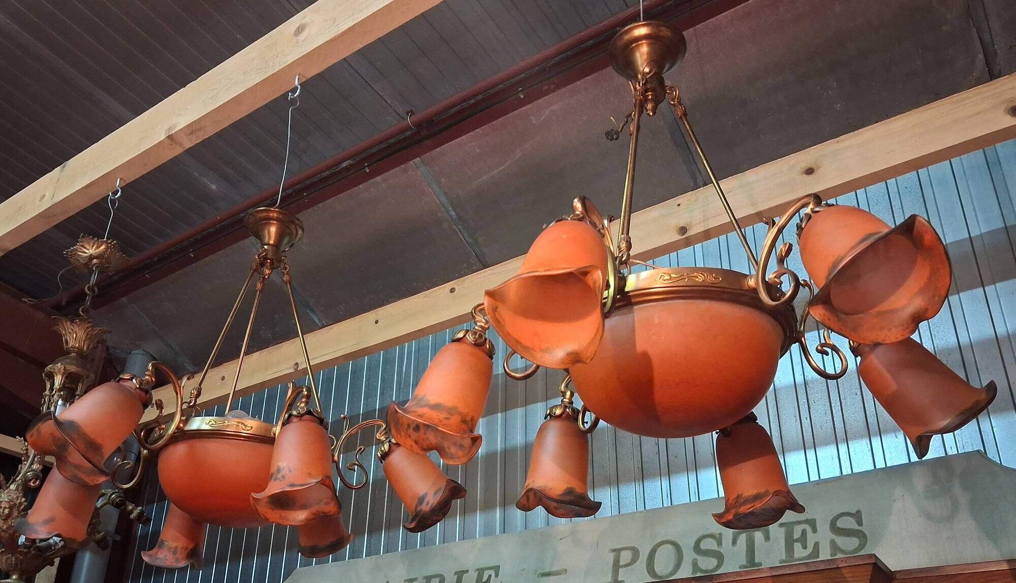 Pair of Art Nouveau style chandeliers in bronze and orange glass paste.