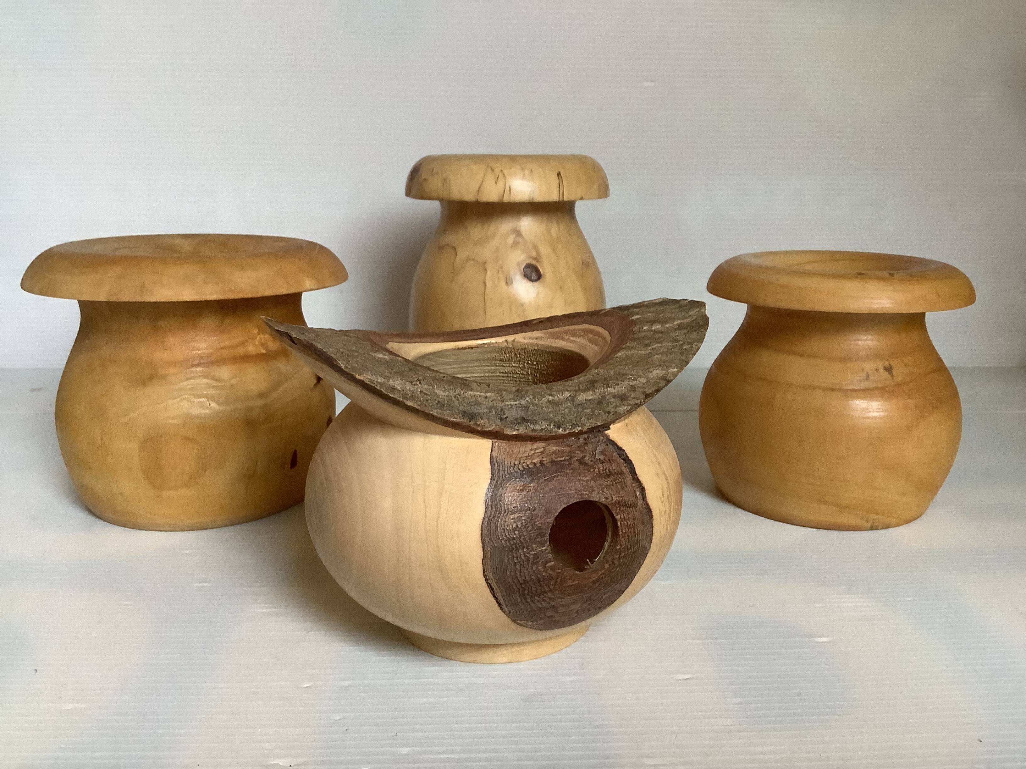 Four solid turned wooden vases