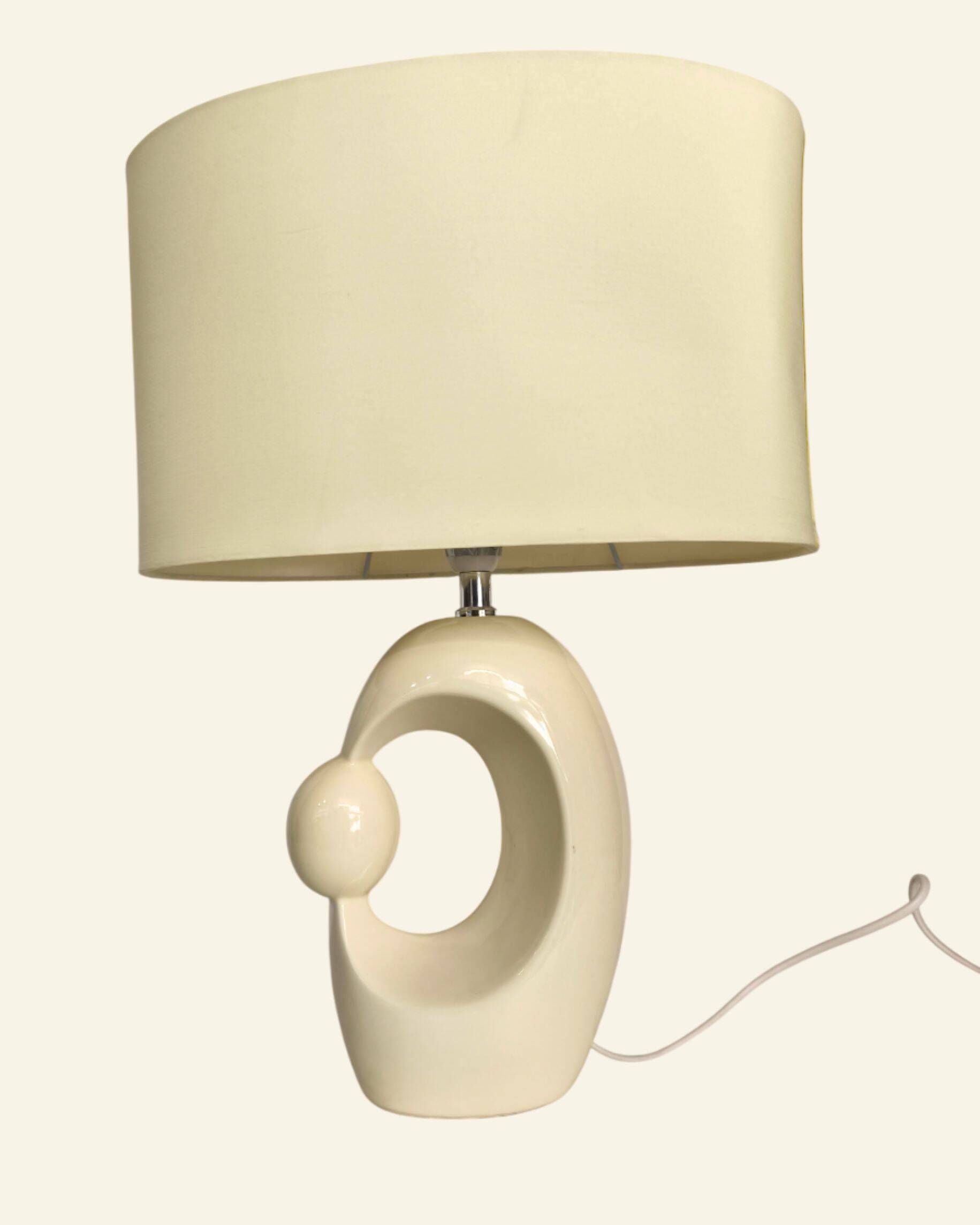 Cream ceramic table lamp with a mid-century design, featuring a lampshade.