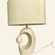 Cream ceramic table lamp with a mid-century design, featuring a lampshade.