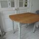 Walnut table with raised flaps, base on verdigris casters.