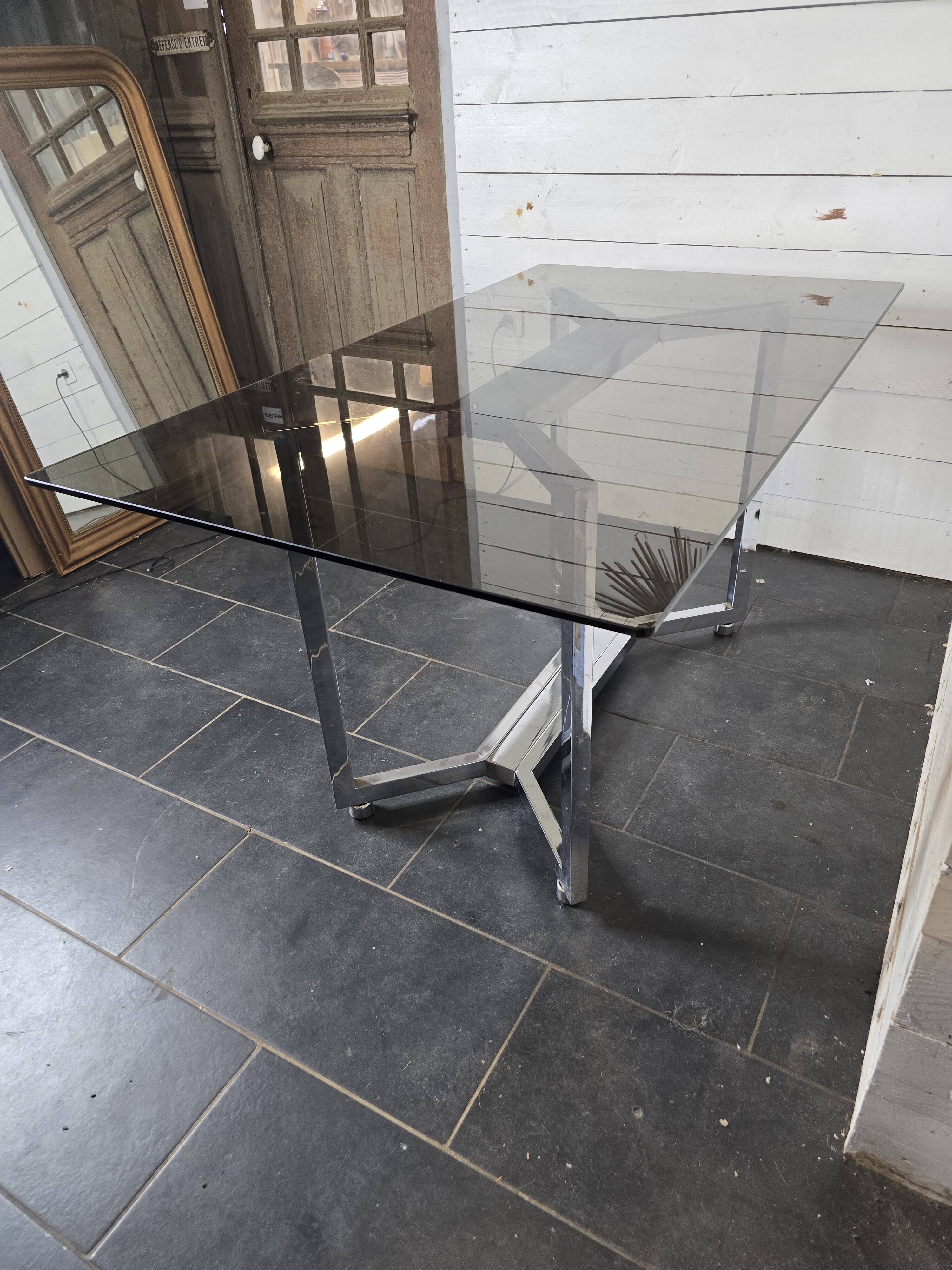 Table en métal chromé dessus verre fumé
