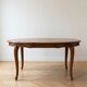 Round extendable dining table in Regency style made of cherry wood.