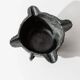 Vintage ceramic ashtray from the 1960s, black, hand-sculpted texture, organic shape.