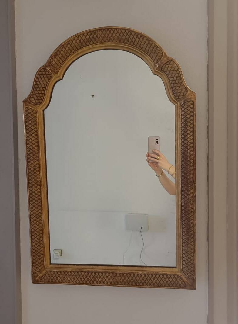 Italian mirror with a sculpted patinated arch, neo-Renaissance style.