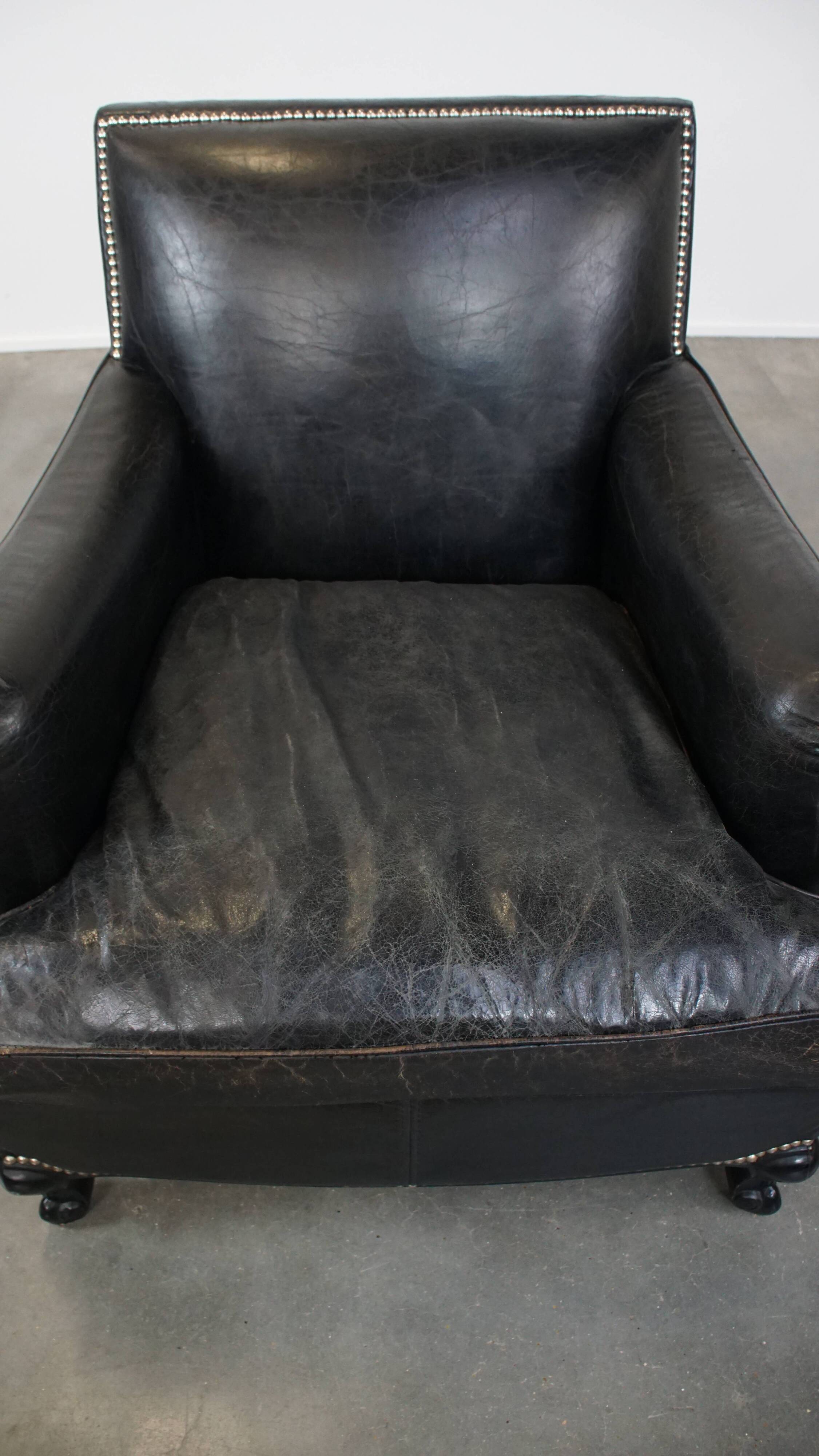 Armchair in black grained cowhide leather with a deep seat