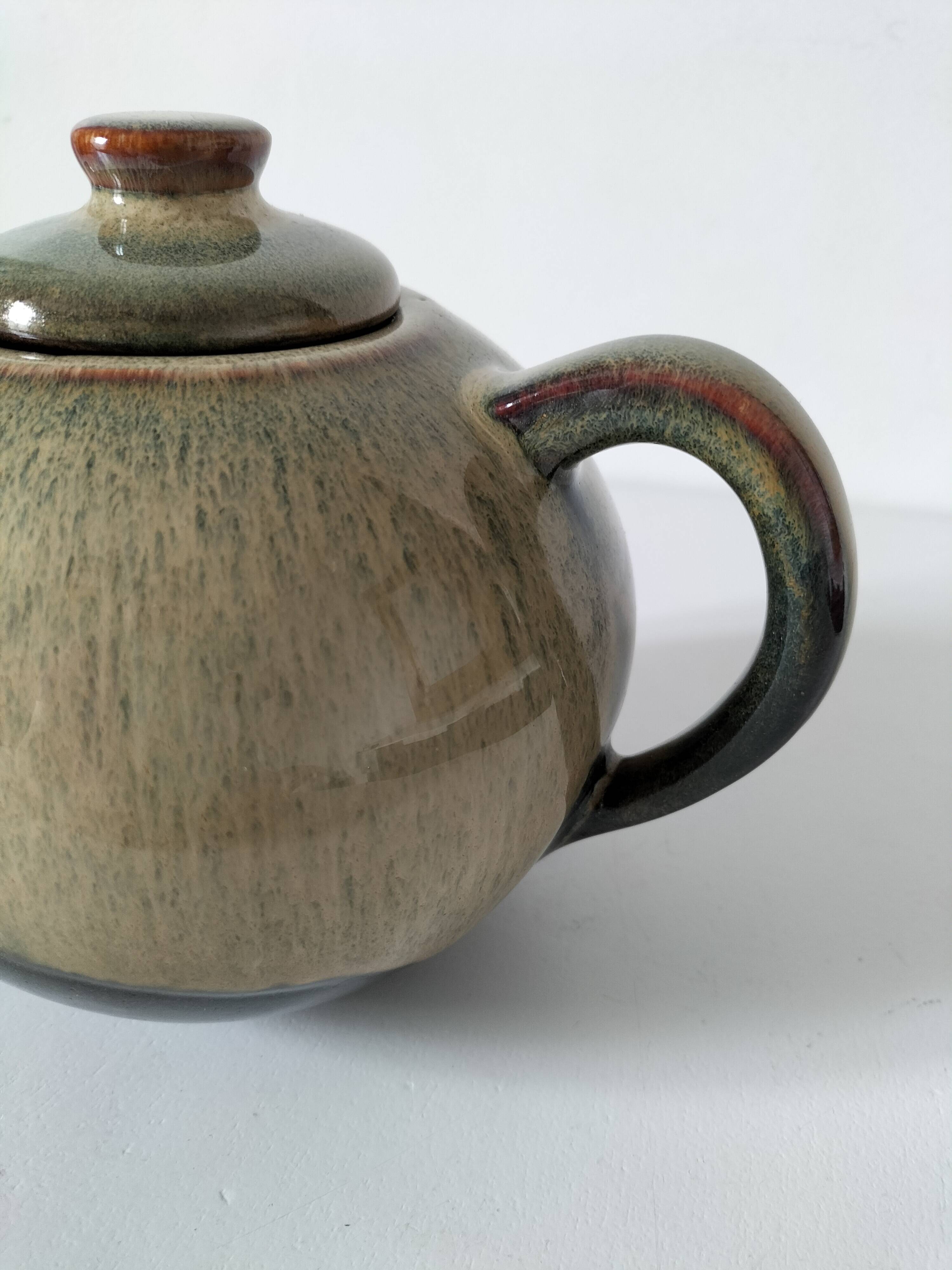 Vintage ceramic teapot with a flame design.