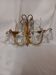 Antique wall light in gilded metal with cut crystal pendants.