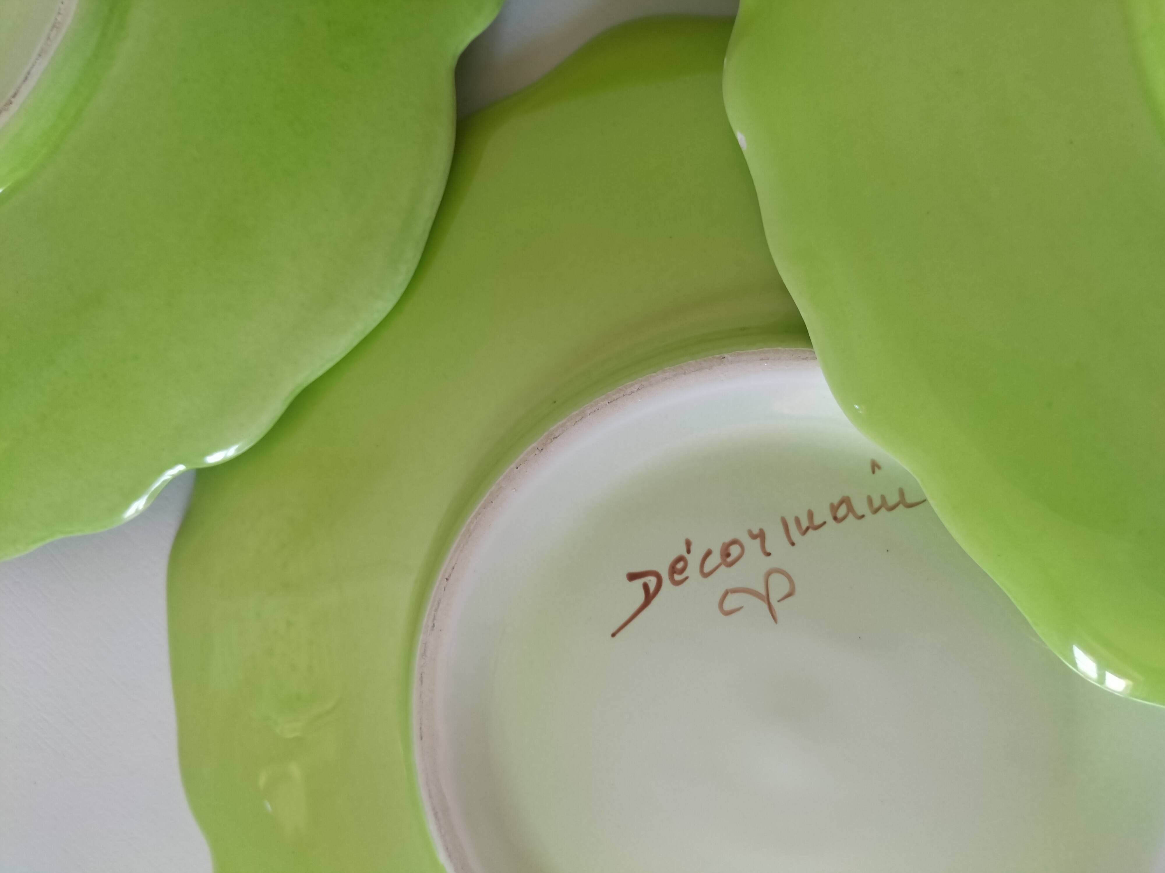 4 hand-decorated earthenware plates with vegetable and green leaf designs.