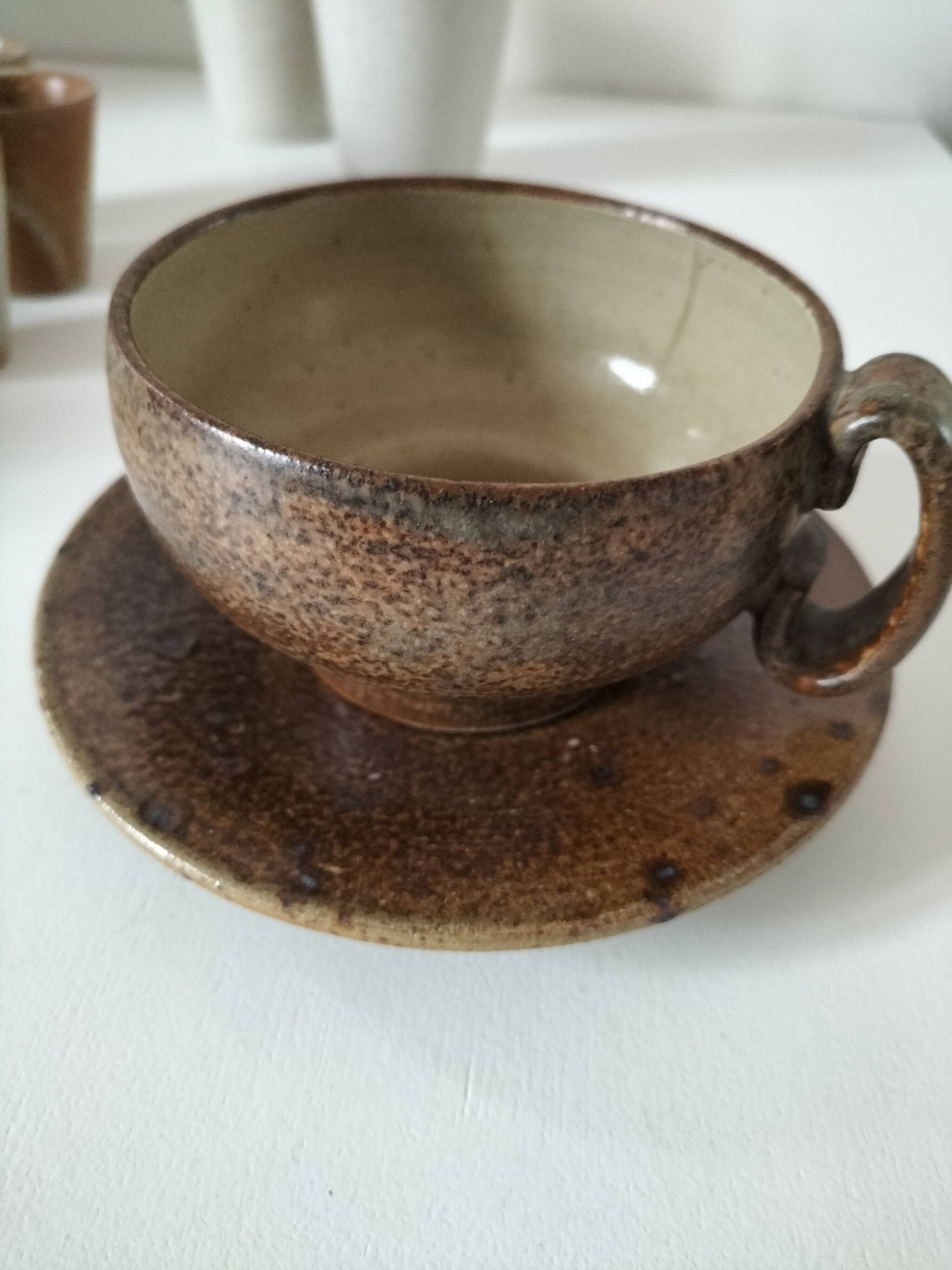 Set of 8 stoneware cups and a mug, shades of beige.