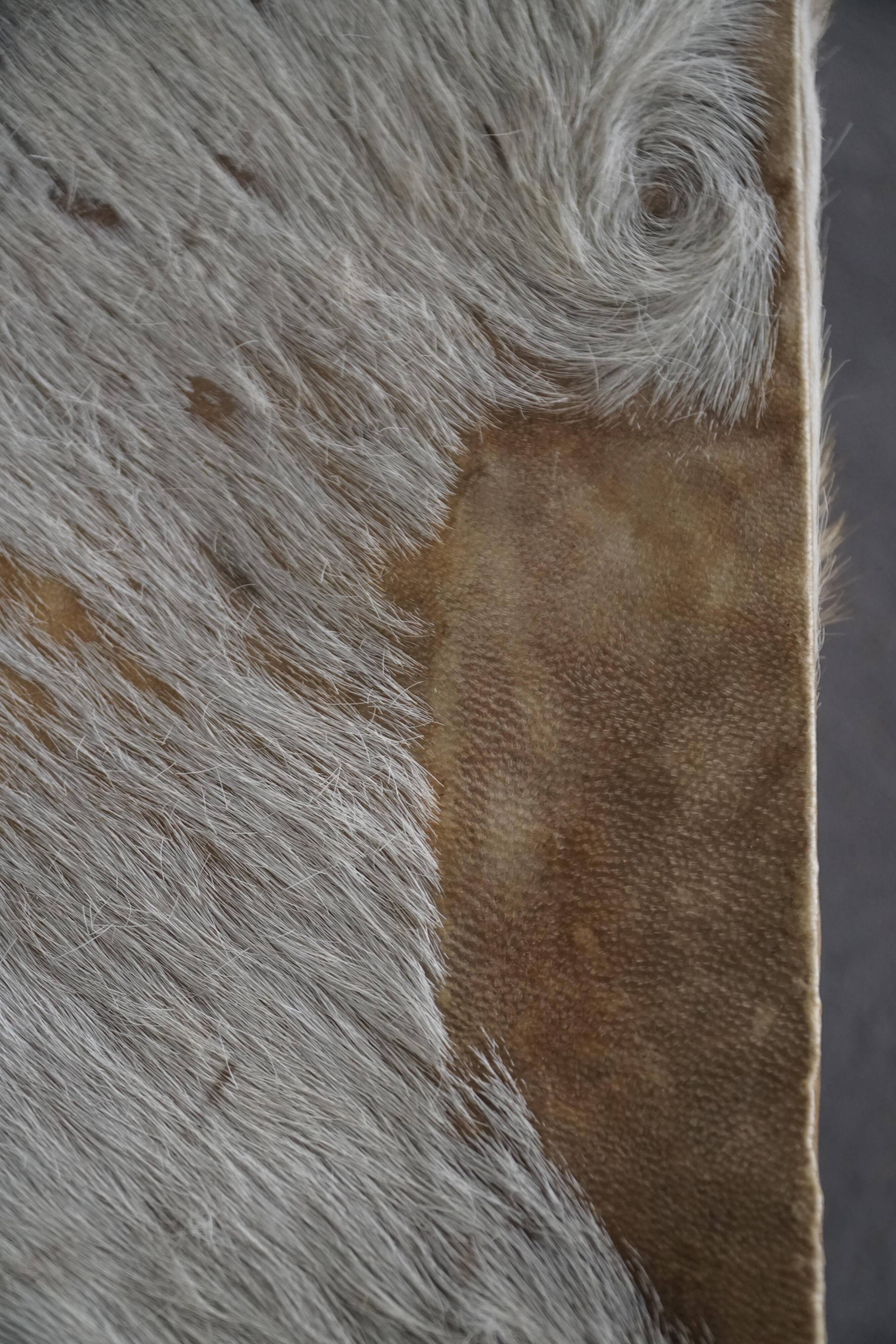 Vintage African artisanal stool, triangular shape with 3 legs, cowhide, 20th century.