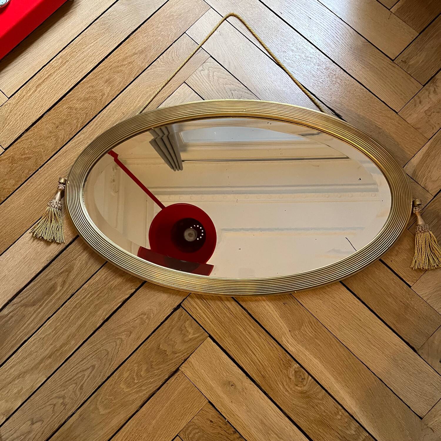 Antique oval beveled mirror adorned with tassels