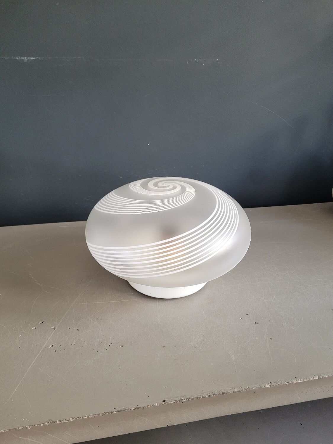 Frosted glass globe ceiling light with spiral patterns.