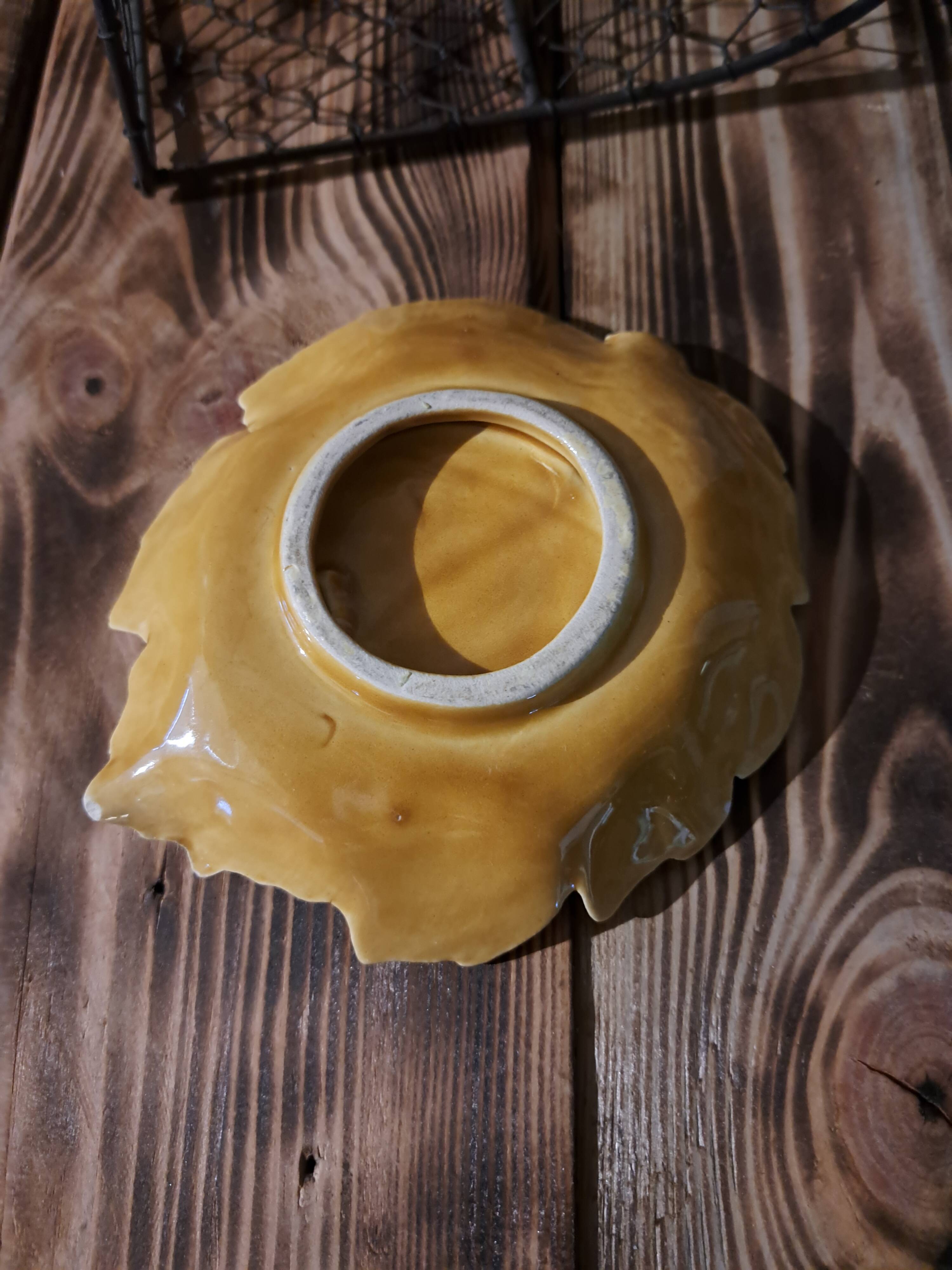 Empty yellow ceramic pocket in the shape of a leaf