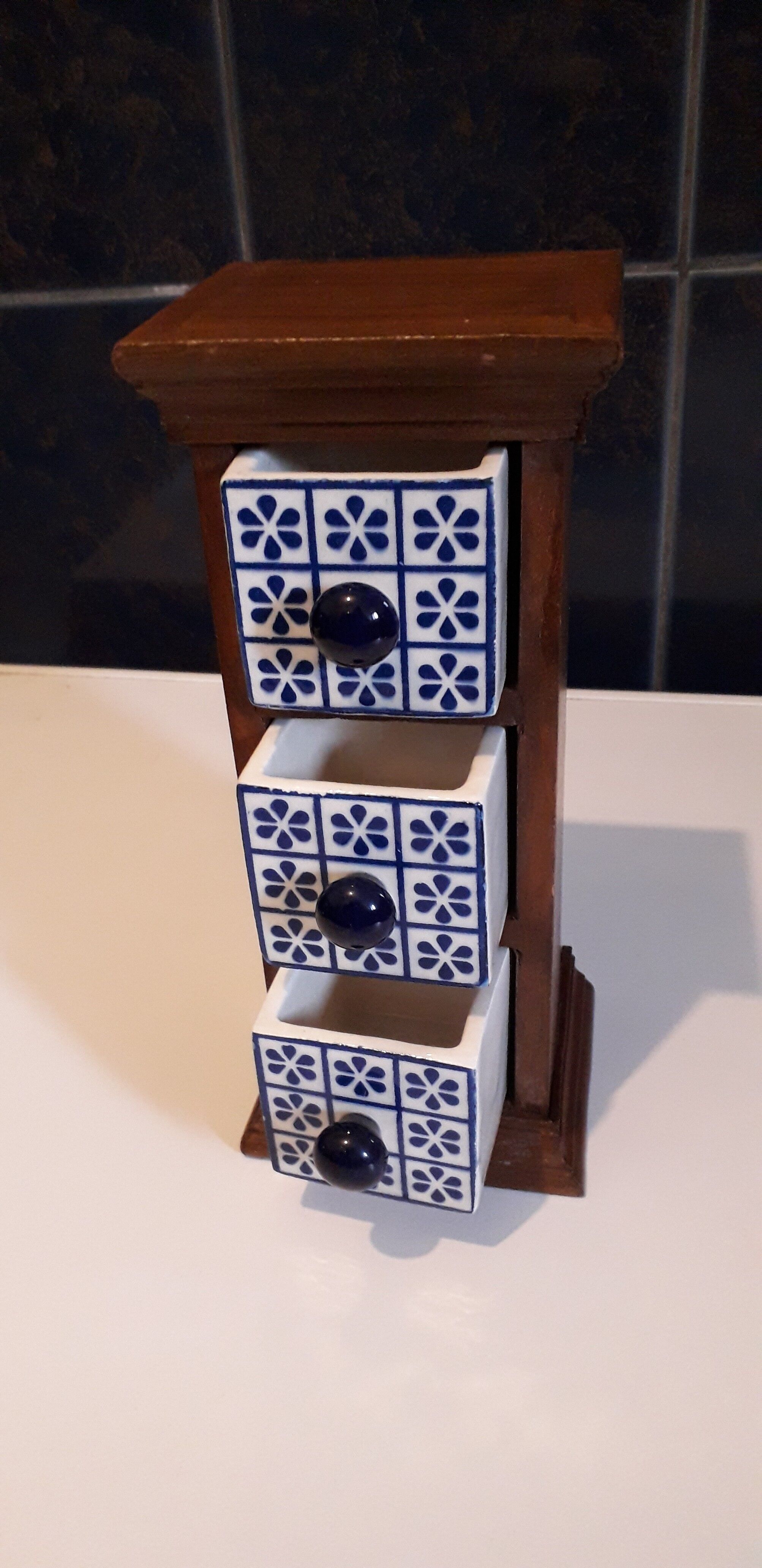 Storage in the form of a small wooden cabinet, with 3 ceramic drawers.