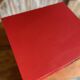 Vintage wooden magazine rack in red.