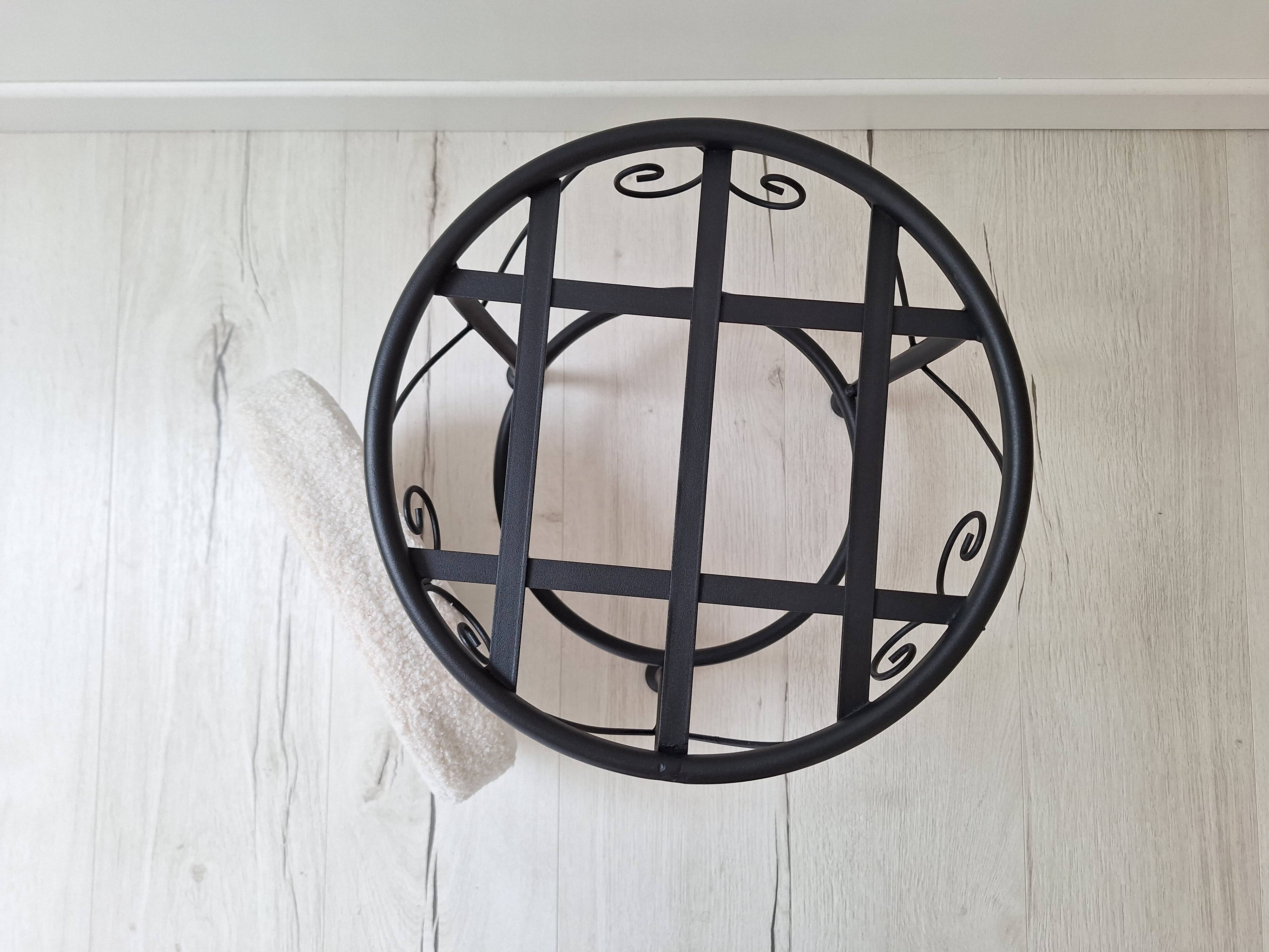 Black iron stool/pouf with its boucle fabric cushion.