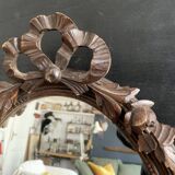 Antique oval mirror in carved wood and Louis XVI style knot