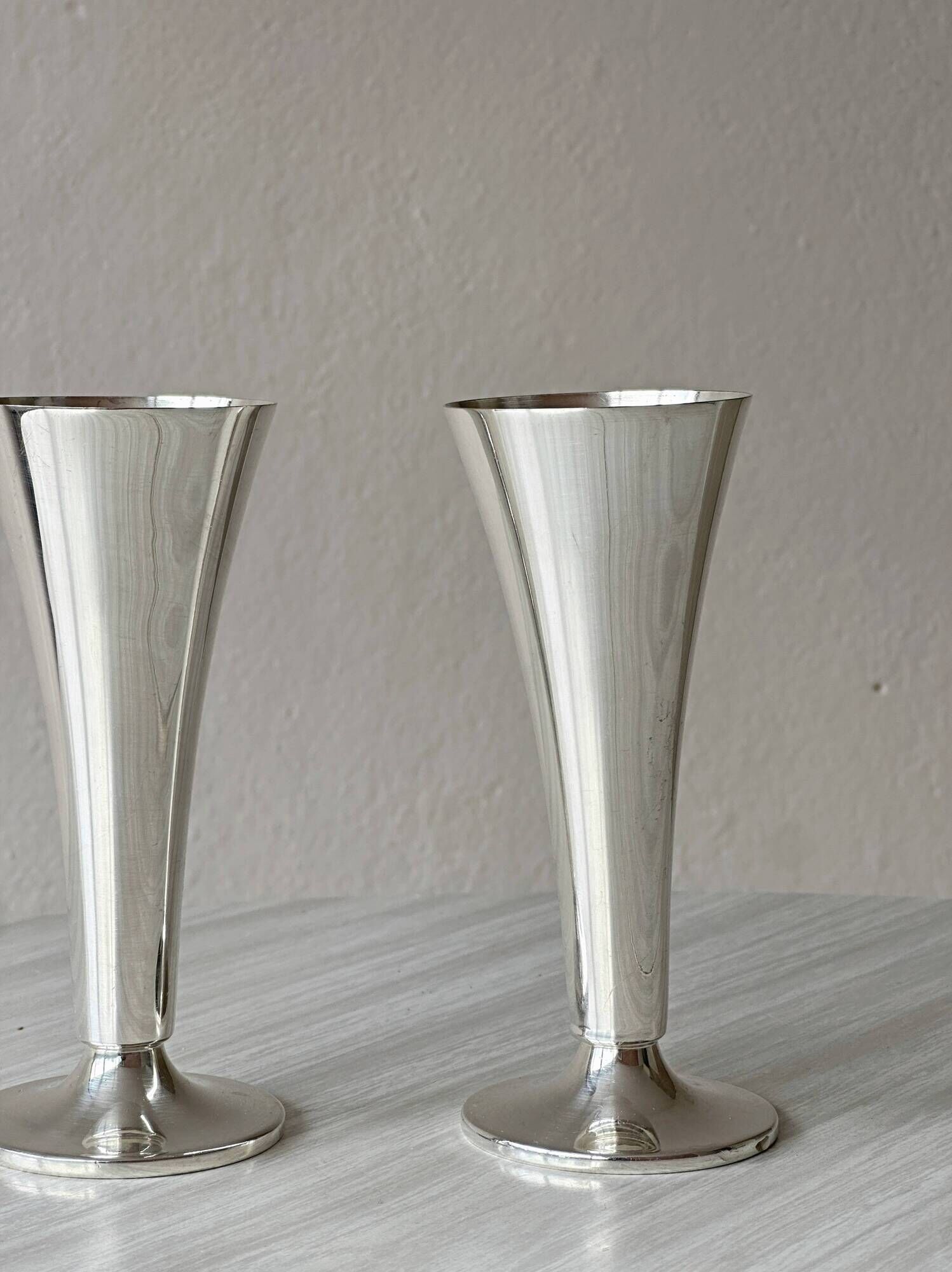 Two silver-coloured lightweight metal flower vases.