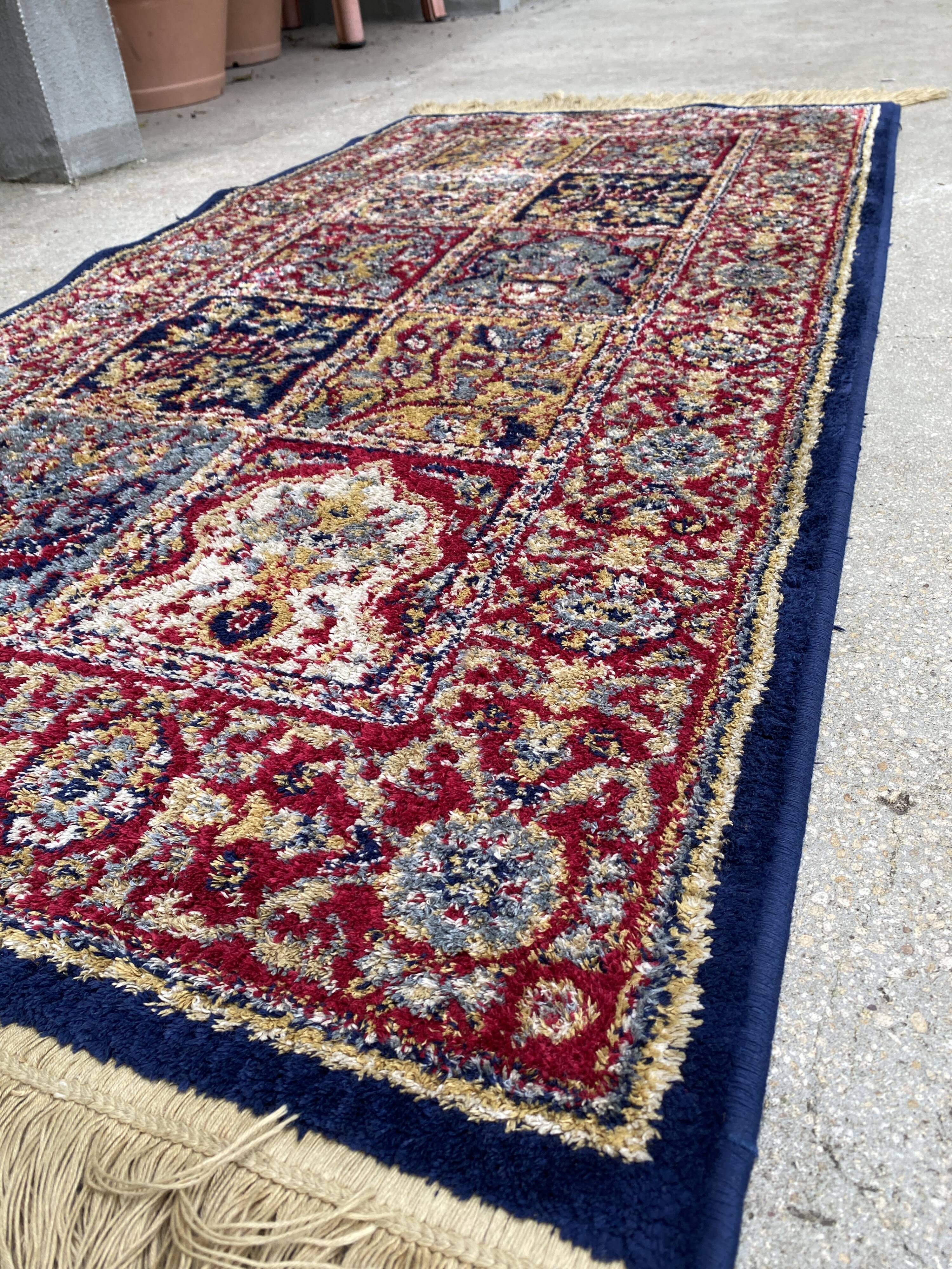 Vintage mechanical Turkish rug with box decoration on a red and navy blue background 139 x 68 cm