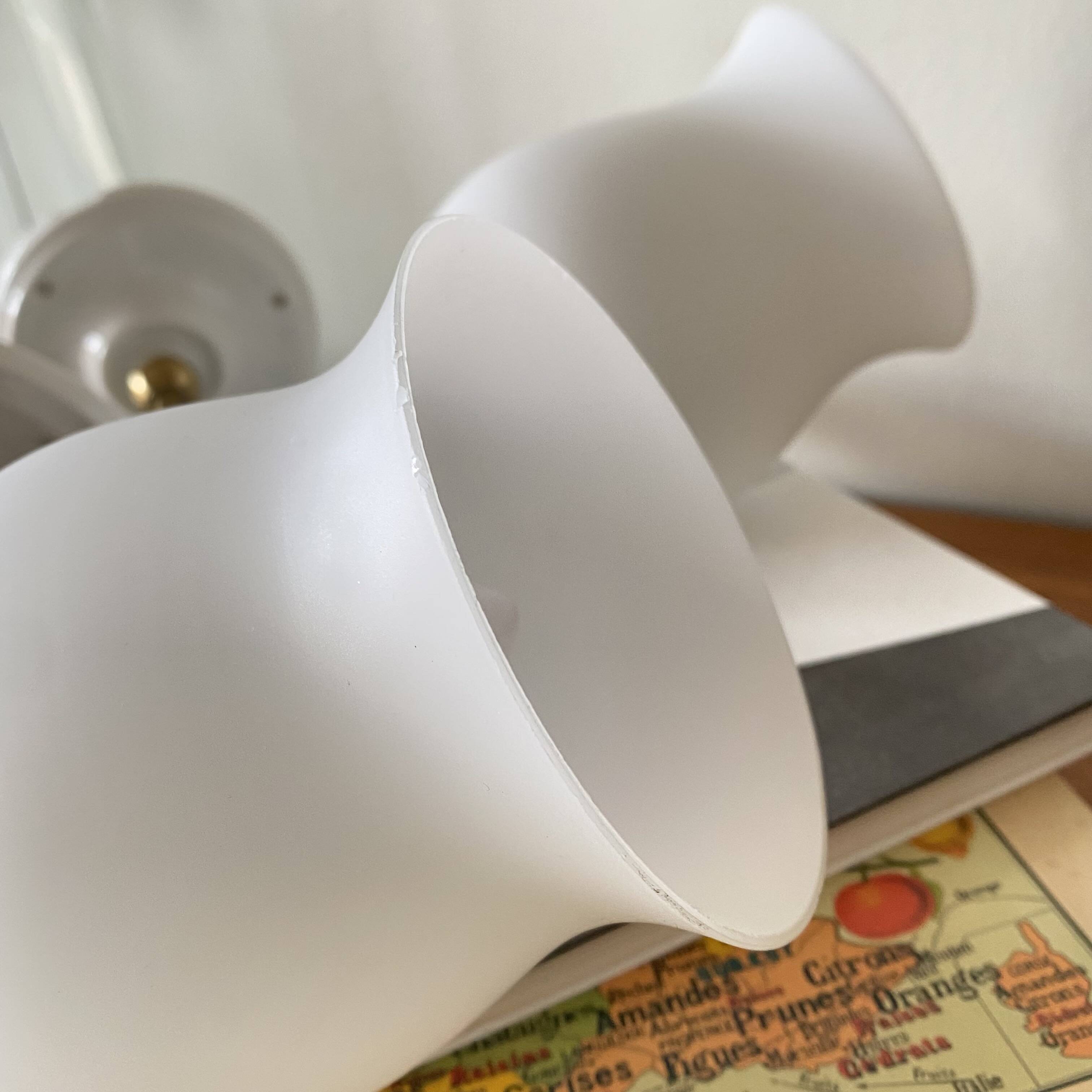 Pair of torch wall lights in brass, white glass and porcelain.