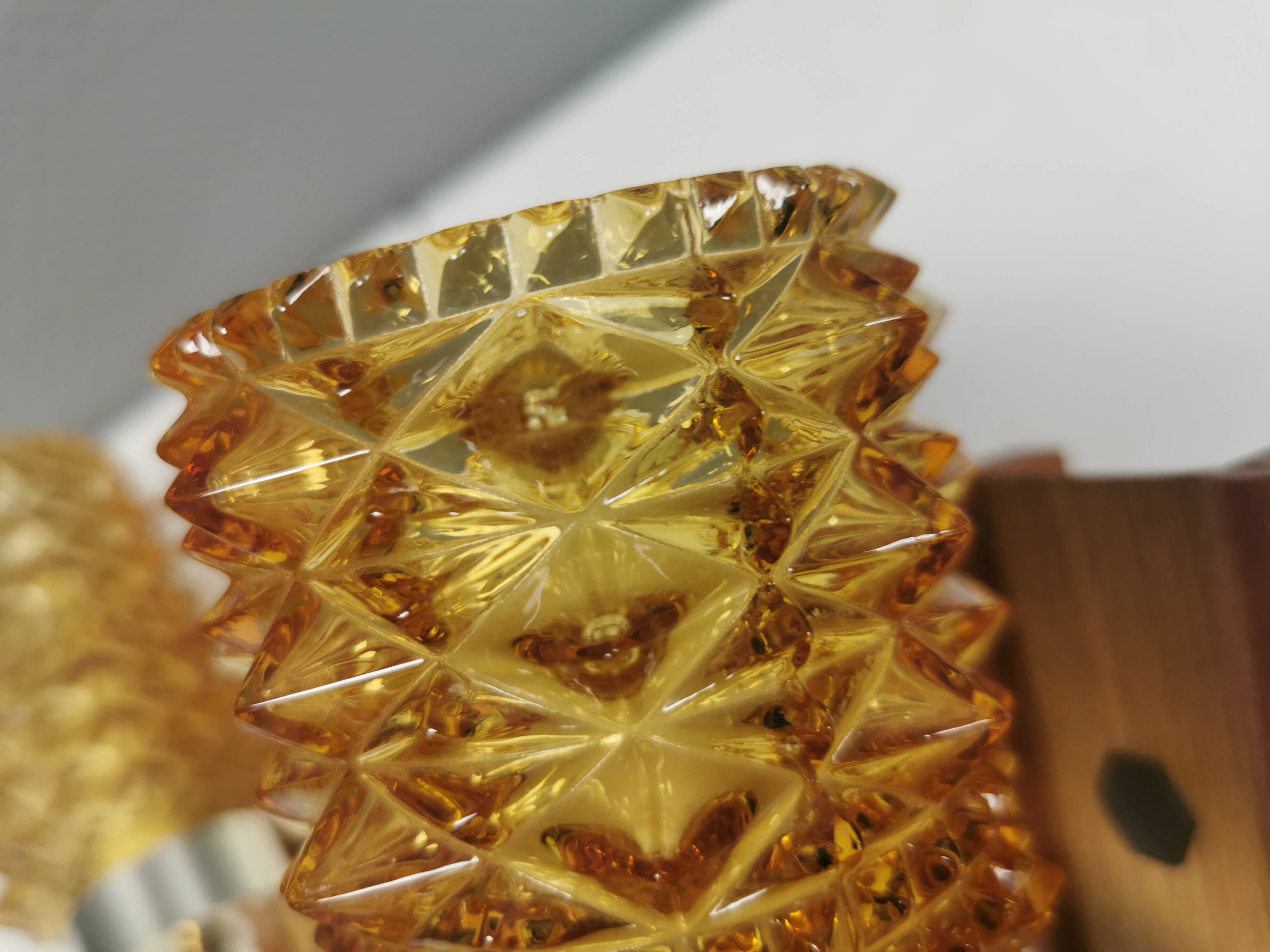 A set of wall lamps in teak wood, with amber colored glass