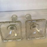 Pair of tall candle holders in the shape of a flower with a square base.