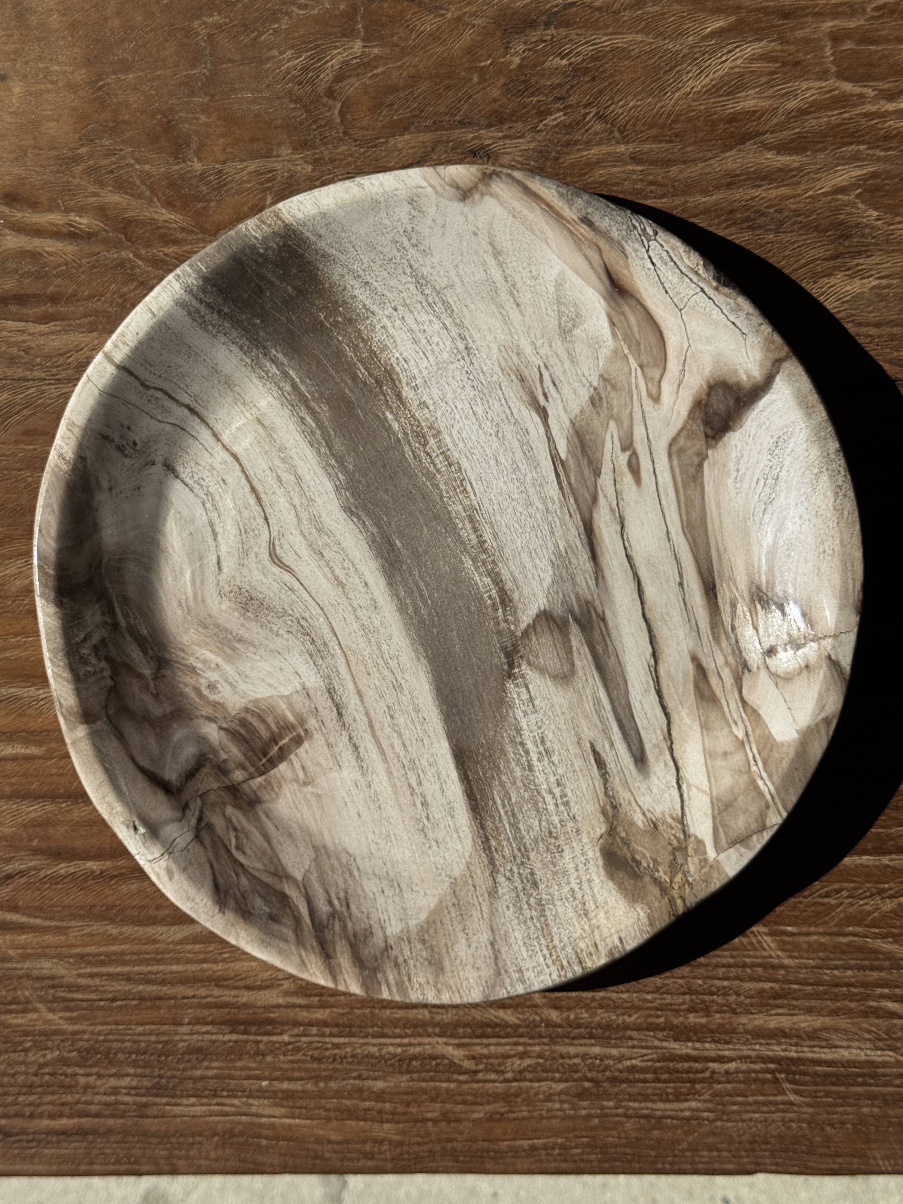Tray, circular dish or plate made of white striped grey petrified wood.