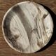 Tray, circular dish or plate made of white striped grey petrified wood.