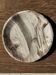 Tray, circular dish or plate made of white striped grey petrified wood.