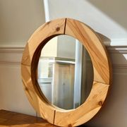 Round mirror in raw wood